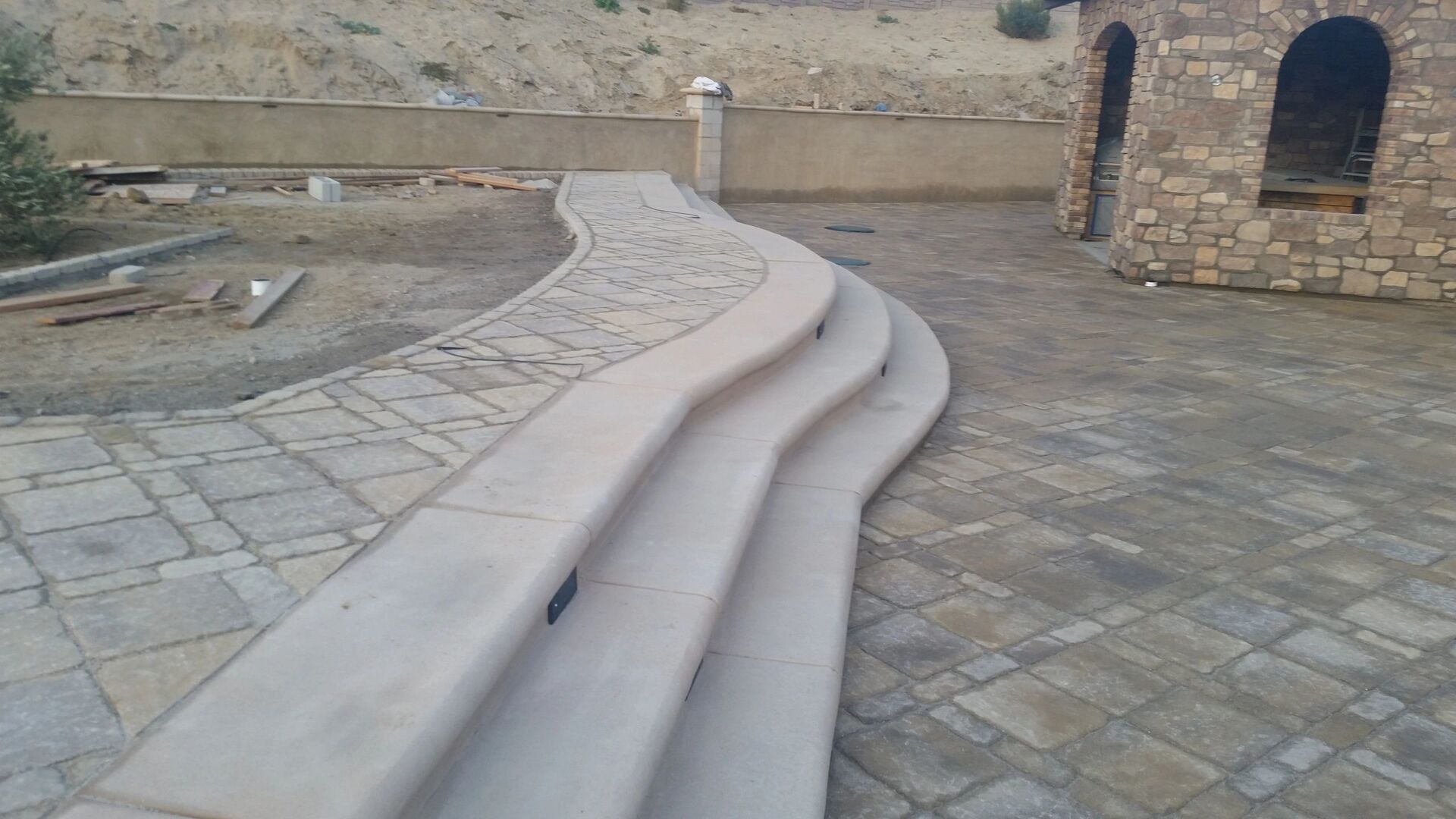 Curved concrete steps with stone paving
